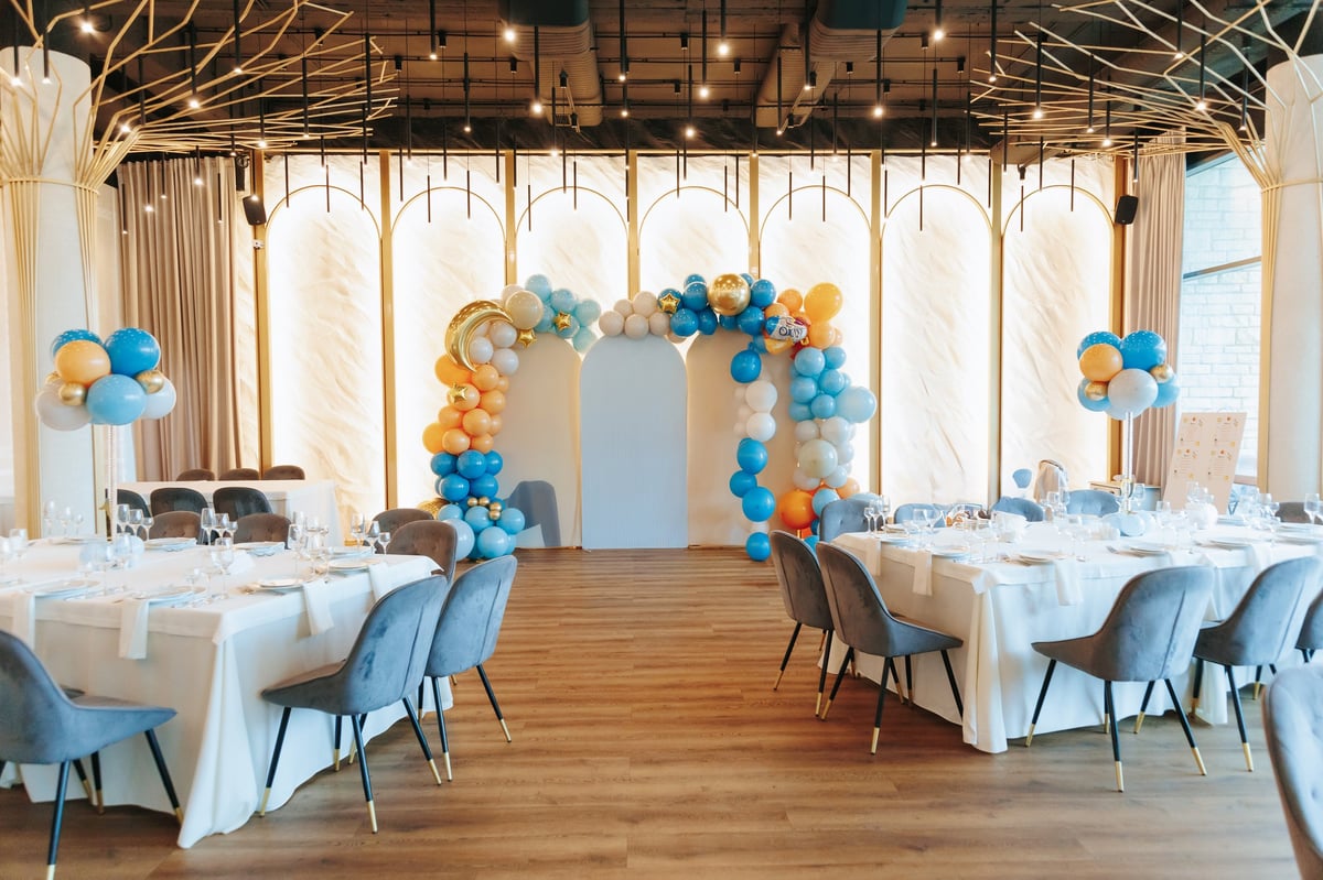 Event planning and venue styling with a balloon arch, white tablecloths and elegant table settings