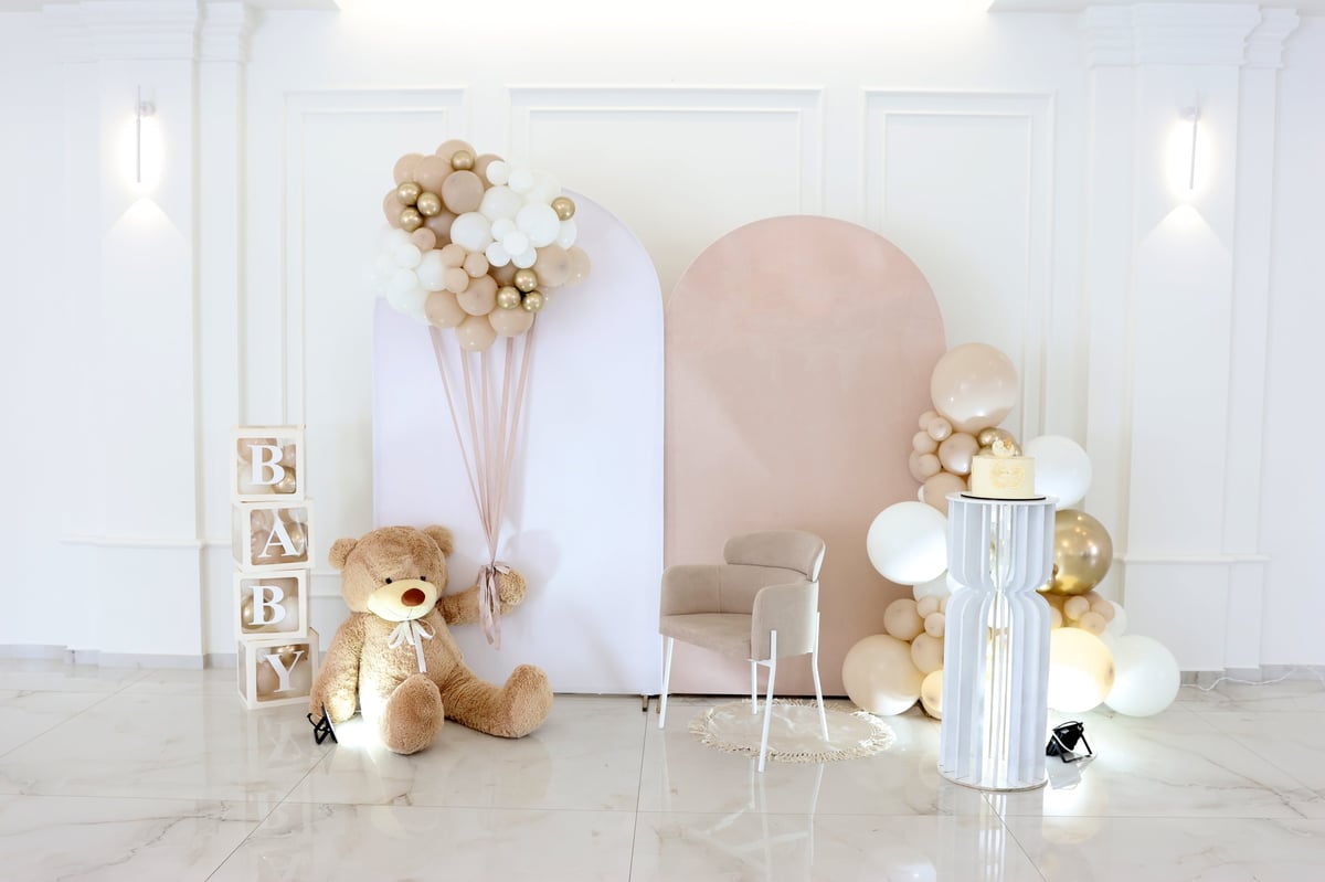 Baby shower decorations with balloon garland, letter blocks and themed styling