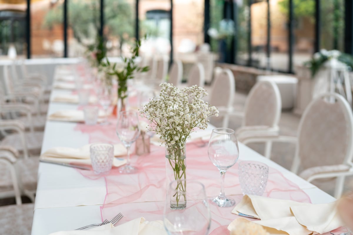 Elegant bridal shower table styling with delicate white flowers, soft pink runner and refined place settings