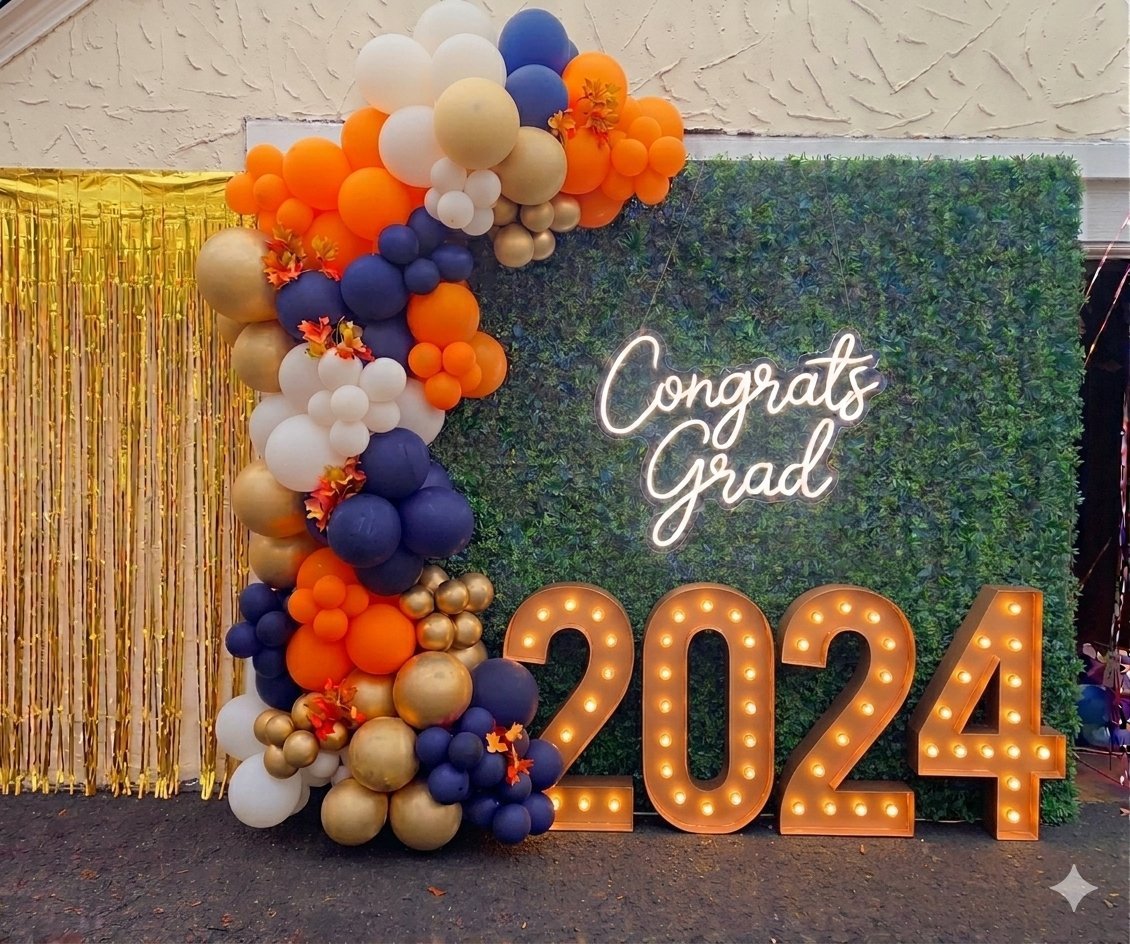 Graduation celebration photo booth with Congrats Grad sign, large illuminated 2024 numbers, and colorful balloon garland in blue, orange, and gold